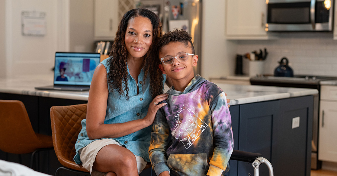 An adult sits beside a child engaged in full time online learning at home, representing a structured virtual public school environment through FLVS Full Time.